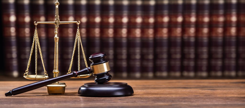 Wooden Gavel With Golden Scale On Table