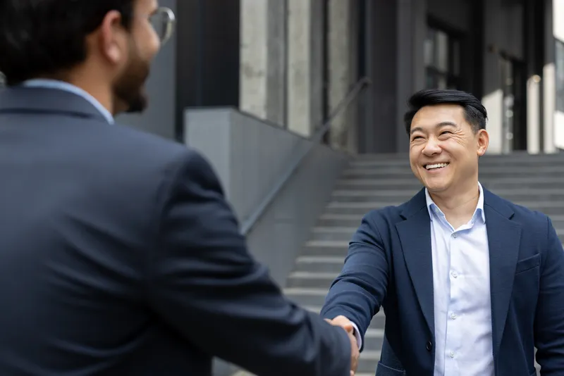 a client happily shaking hands with his defence lawyer in Singapore