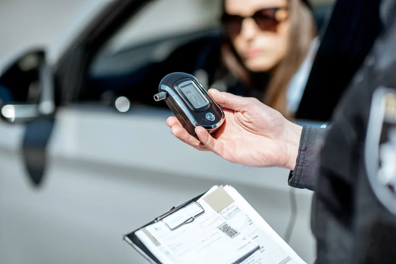 an officer checking a breathalyser result | evidence that a dui lawyer reviews