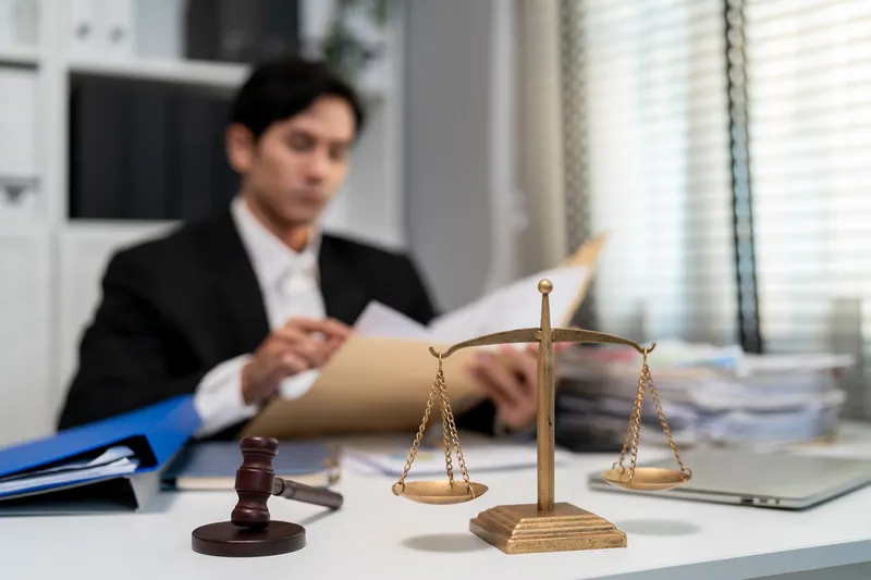 a lawyer for theft in Singapore reviewing submitted files of statements and evidence for his client
