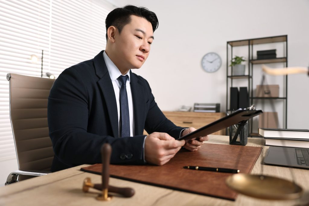 A lawyer reviews case materials on a tablet during pre-trial preparation.